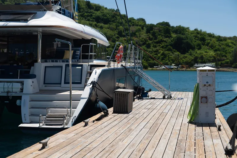 Andromeda Yacht Photos Pics Lagoon 620 yacht docked at a wooden pier, surrounded by lush greenery, 2016 model.