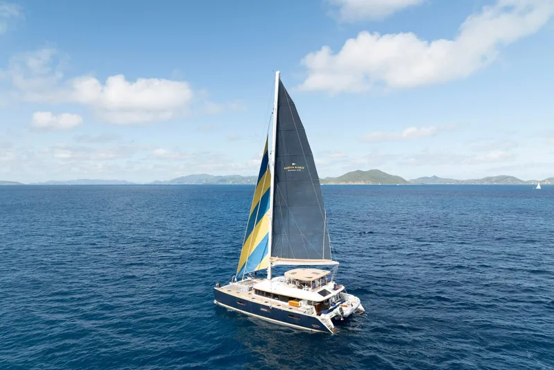 Andromeda Yacht Photos Pics 2016 Lagoon 620 catamaran sailing on open sea under clear blue sky.