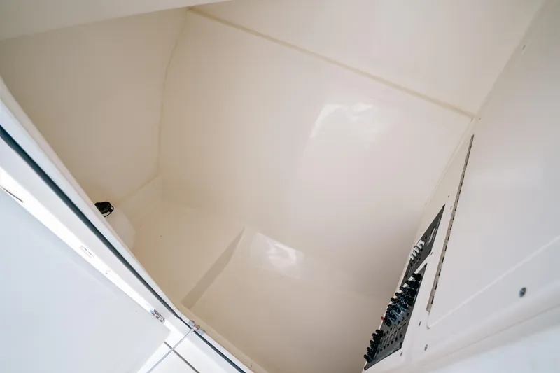 + Sea Keeper 2 Yacht Photos Pics 2024 Cobia 330 Dual Console interior compartment, featuring sleek white surfaces and control panel.