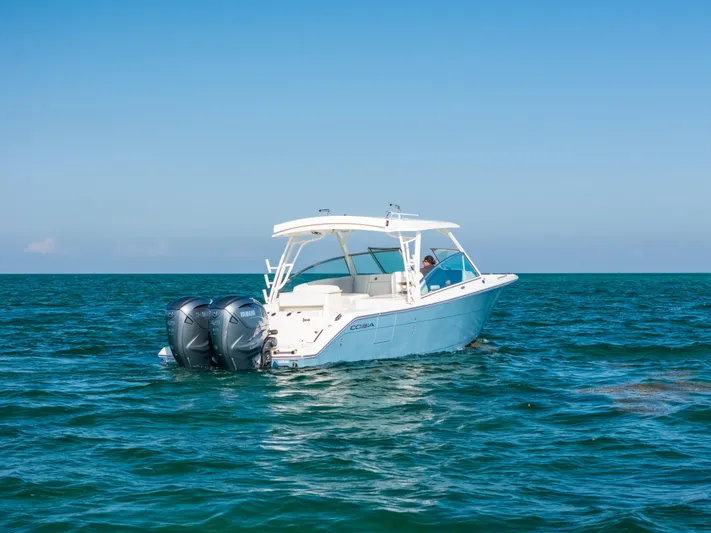 + Sea Keeper 2 Yacht Photos Pics 2024 Cobia 330 Dual Console boat on open sea, featuring twin outboard engines.