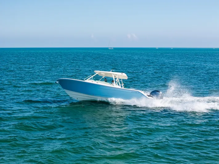 + Sea Keeper 2 Yacht Photos Pics 2024 Cobia 330 Dual Console boat cruising on open blue ocean.