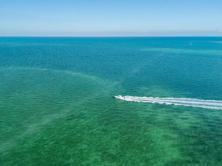 + Sea Keeper 2 Yacht Photos Pics 2024 Cobia 330 Dual Console cruising on clear blue ocean waters.