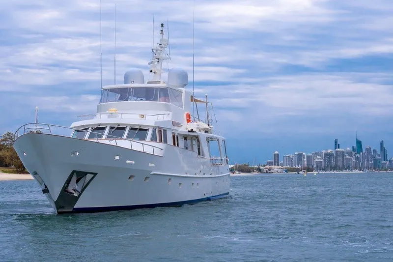 Atlantic Princess Yacht Photos Pics Custom GeTa 86ft Motor Yacht, 1992, cruising near city skyline under cloudy sky.