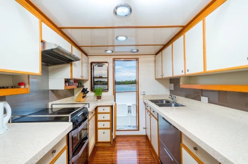 Atlantic Princess Yacht Photos Pics Kitchen interior of 1992 GeTa 86ft Motor Yacht with modern appliances and wooden flooring.