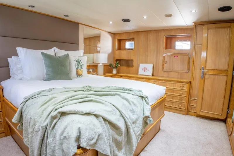 Atlantic Princess Yacht Photos Pics Luxurious bedroom interior on 1992 Custom GeTa 86ft Motor Yacht, featuring elegant wood finishes.
