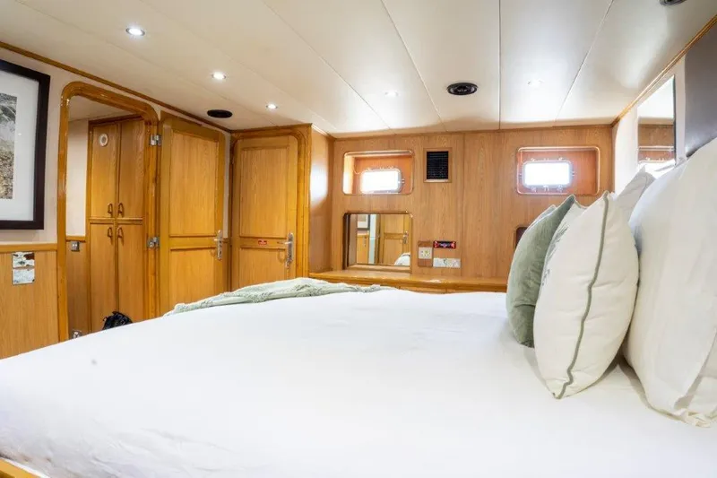 Atlantic Princess Yacht Photos Pics Luxurious bedroom interior of 1992 GeTa 86ft Motor Yacht with wooden accents and plush bedding.