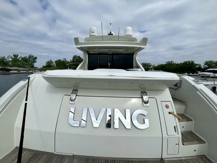  Yacht Photos Pics 2011 Azimut 62S Italia yacht with "LIVING" on the stern, docked under cloudy skies.