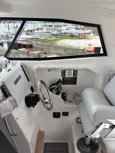  Yacht Photos Pics Interior of a 2020 Protector 310 Targa boat with steering wheel and controls.
