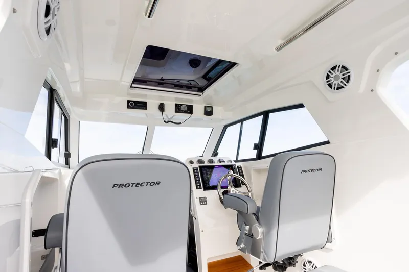  Yacht Photos Pics Interior of 2020 Protector 310 Targa boat, featuring modern helm and seating.