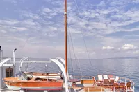 Deck of 1902 Ailsa Shipbuilding vessel with lifeboats and seating, under a clear sky.