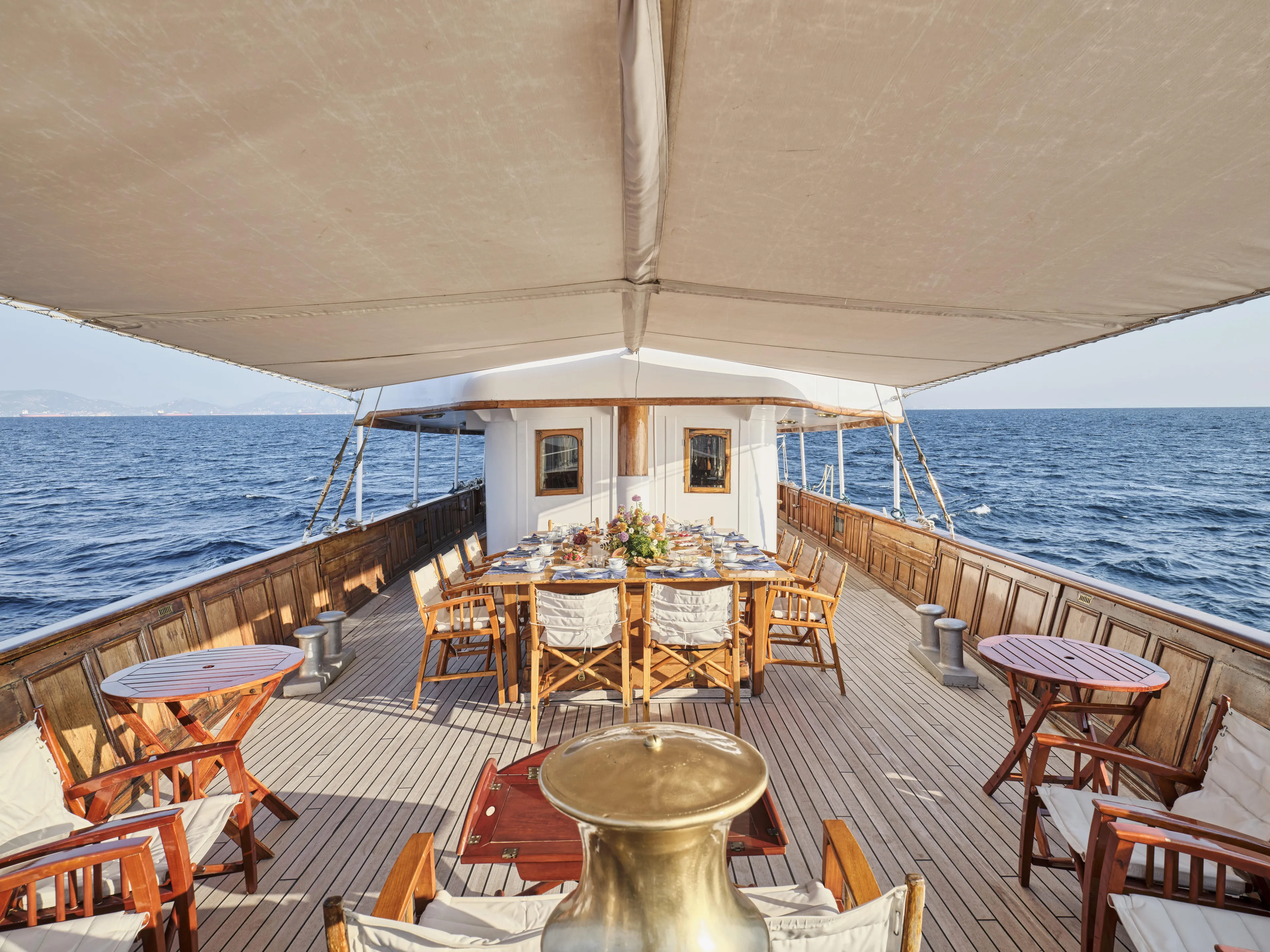 Luxurious 1902 Ailsa Shipbuilding yacht deck with elegant dining setup and ocean view.