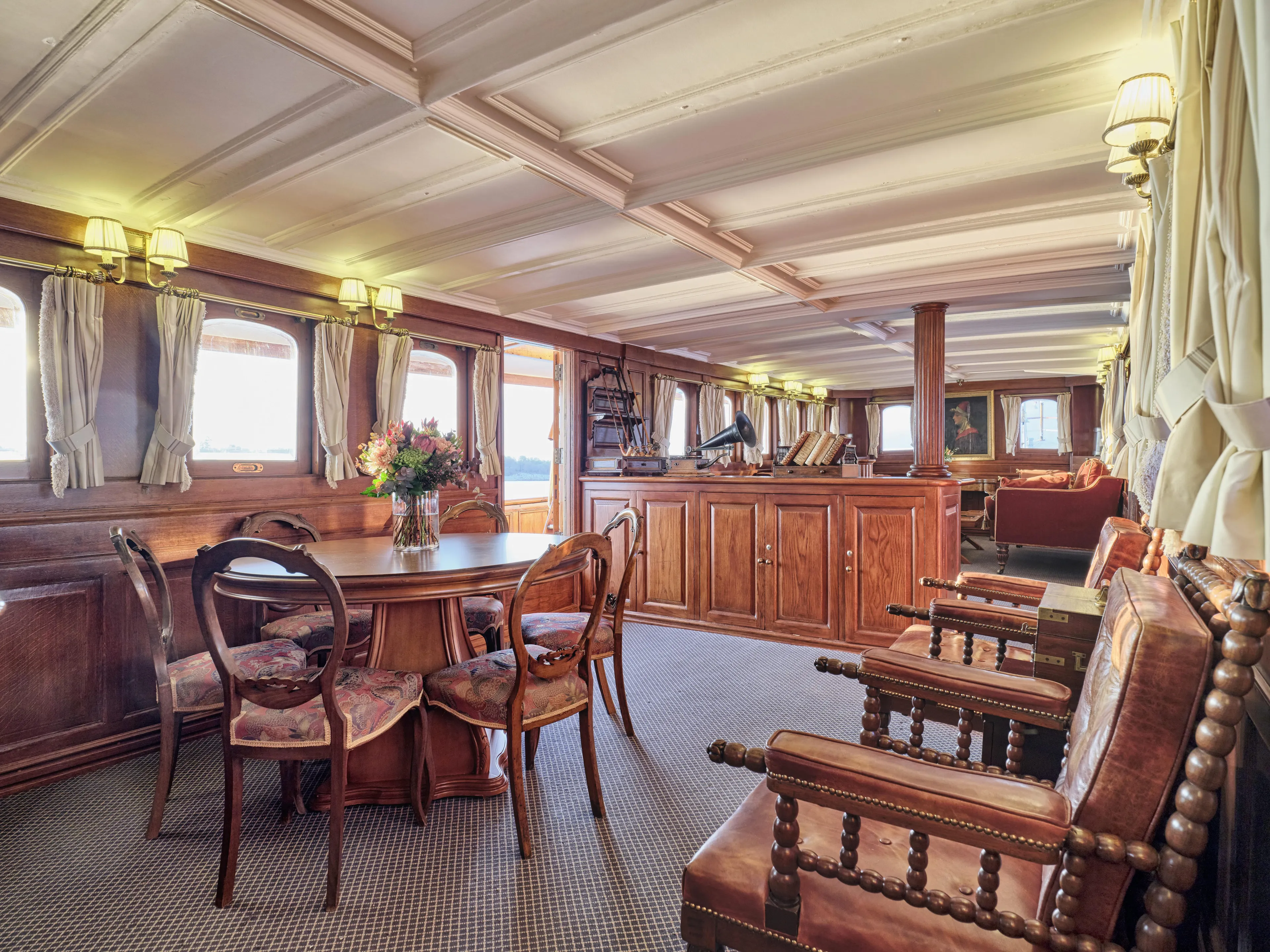 Luxurious vintage ship interior with wooden furniture, elegant decor, and soft lighting, built in 1902.