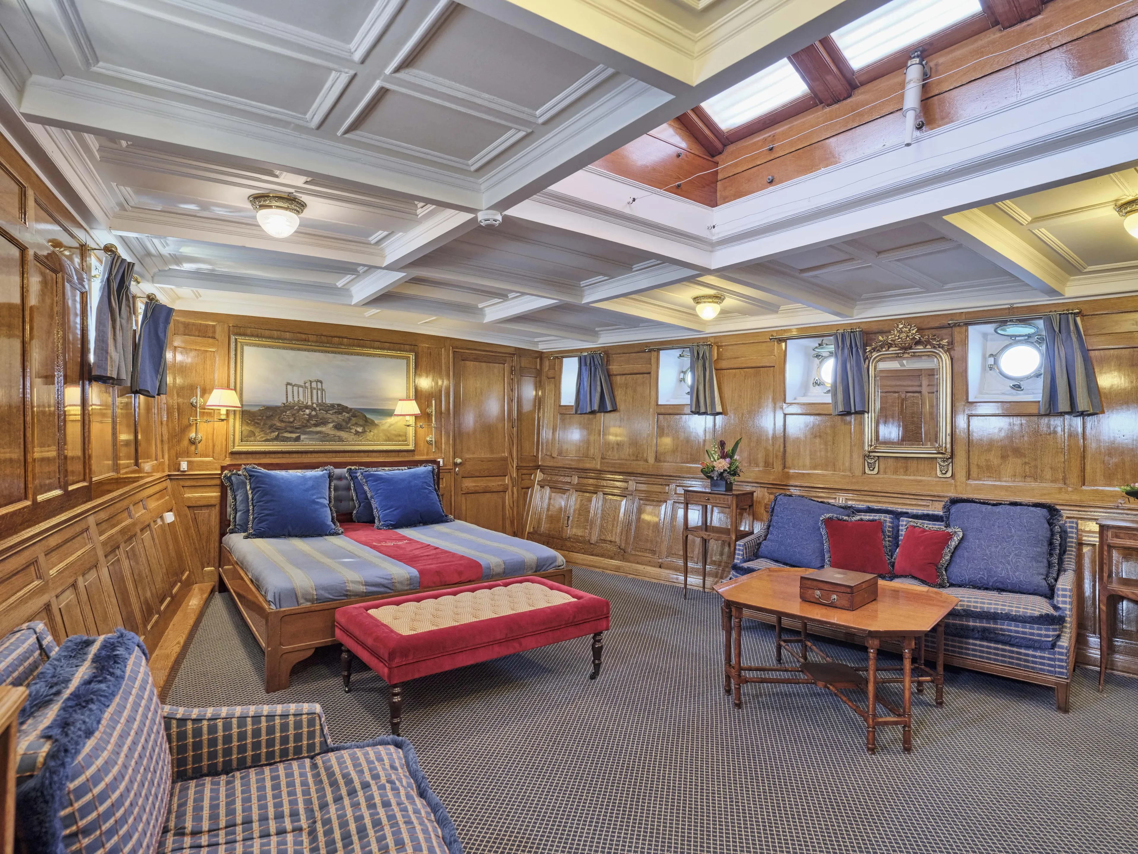 Luxurious vintage ship cabin with elegant wood paneling, plush seating, and classic decor, built in 1902.