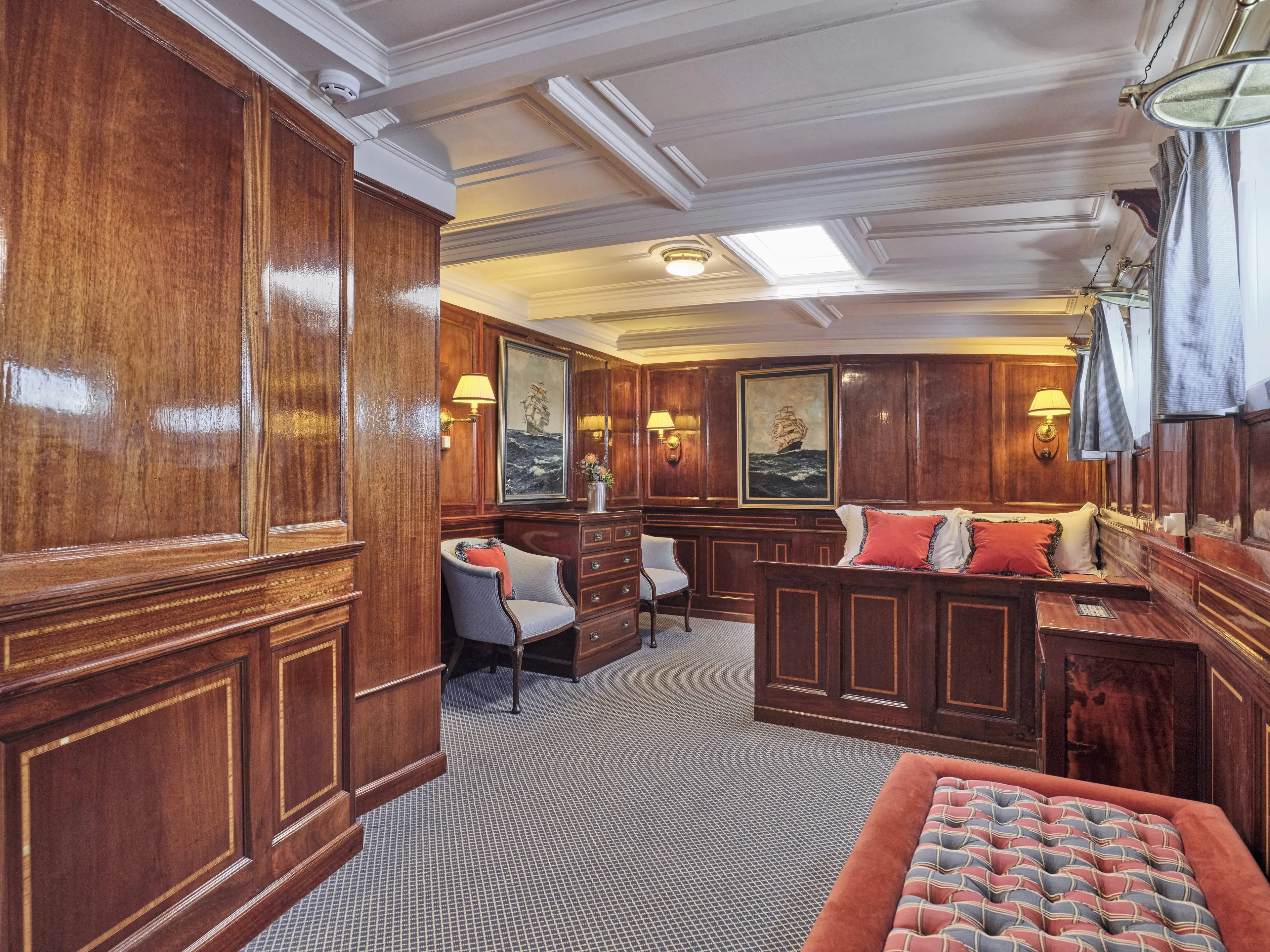 Luxurious vintage ship interior with wood paneling, elegant seating, and nautical artwork, Ailsa Shipbuilding 1902.