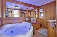 Luxurious wooden bathroom with jacuzzi on a 1902 Ailsa Shipbuilding custom vessel.