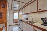 Kitchen interior of a 1902 Ailsa Shipbuilding vessel, featuring modern appliances and ocean view.