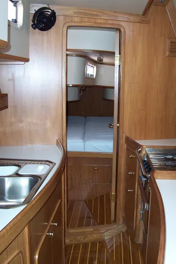 Blue Yacht Photos Pics Interior of 1994 C&C 51 XL C/B yacht with wooden cabinetry and compact kitchen.