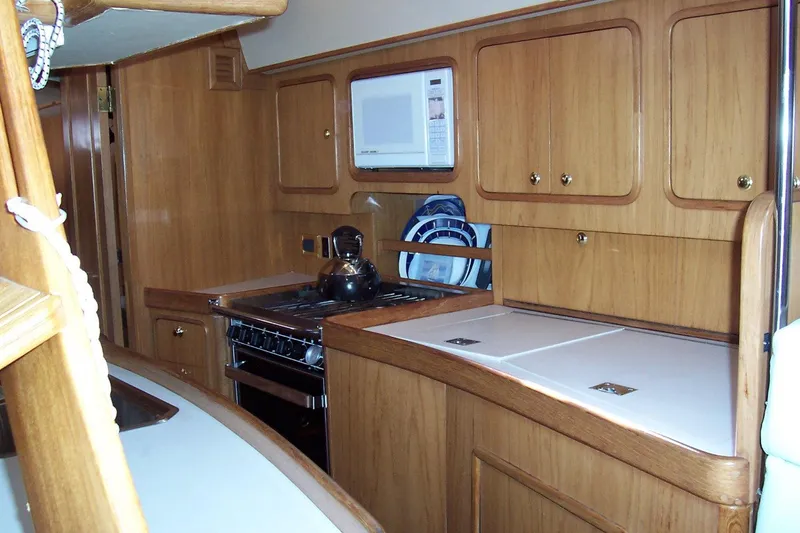 Blue Yacht Photos Pics 1994 C&C 51 XL C/B yacht kitchen with wooden cabinets and modern appliances.