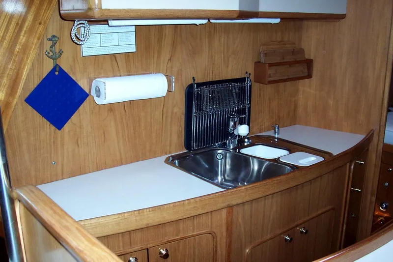 Blue Yacht Photos Pics 1994 C&C 51 XL C/B yacht kitchen with wooden cabinetry and stainless steel sink.