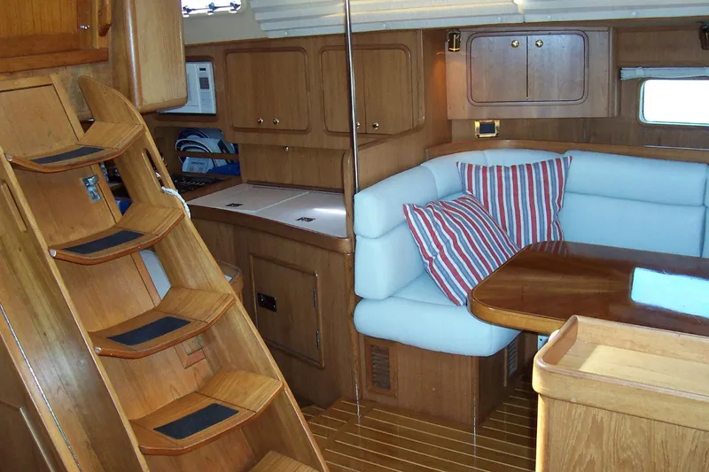 Blue Yacht Photos Pics Interior of 1994 C&C 51 XL C/B yacht with wooden cabinetry and cozy seating area.