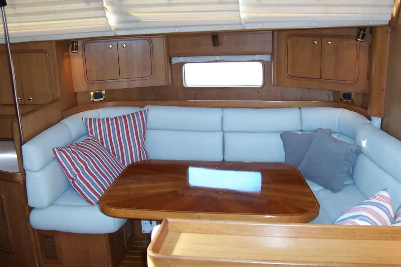 Blue Yacht Photos Pics Cozy interior of 1994 C&C 51 XL C/B yacht with cushioned seating and wooden table.