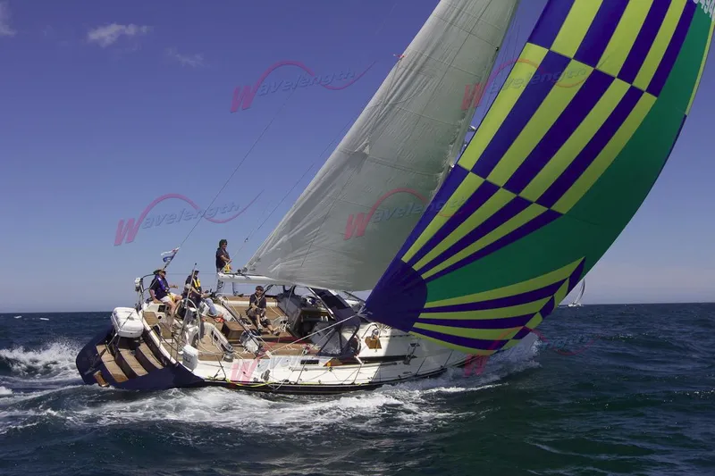 Blue Yacht Photos Pics Sailing yacht C&C 51 XL C/B 1994 with colorful spinnaker on open sea.