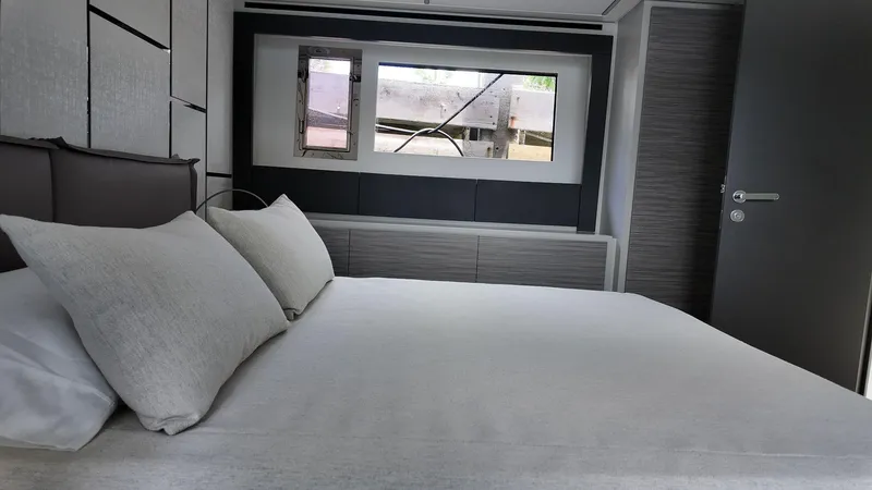 Our Trade Yacht Photos Pics Luxurious bedroom interior of 2022 Pershing 6X yacht with modern design and window view.