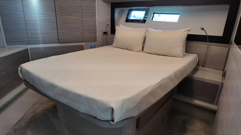 Our Trade Yacht Photos Pics Luxurious bedroom interior of 2022 Pershing 6X yacht with modern design and comfortable bedding.