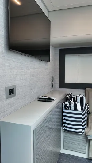 Our Trade Yacht Photos Pics Interior of 2022 Pershing 6X yacht with modern TV and striped storage basket.