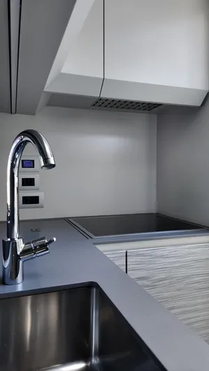 Our Trade Yacht Photos Pics Modern kitchen interior on 2022 Pershing 6X yacht, featuring sleek faucet and induction cooktop.