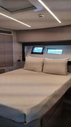 Our Trade Yacht Photos Pics Luxurious bedroom interior of 2022 Pershing 6X yacht with modern design and cozy bedding.