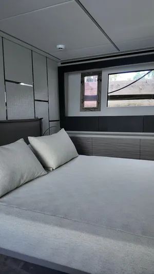Our Trade Yacht Photos Pics Luxurious bedroom interior of 2022 Pershing 6X yacht with modern design and comfortable bedding.
