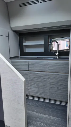 Our Trade Yacht Photos Pics Modern kitchen interior of 2022 Pershing 6X yacht with sleek cabinetry and faucet.