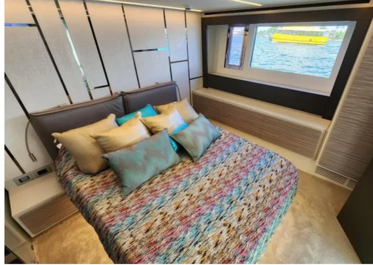 Our Trade Yacht Photos Pics Luxurious bedroom interior of 2022 Pershing 6X yacht with colorful bedding and sea view.