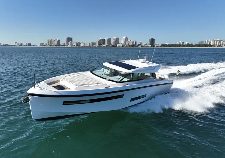  Yacht Photos Pics Delta Powerboats 48 Coupe 2026 cruising on open water near city skyline.