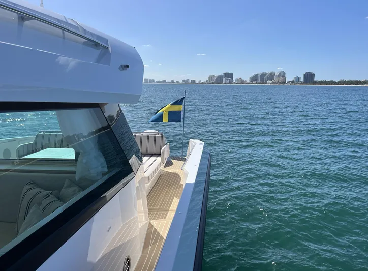  Yacht Photos Pics Delta Powerboats 48 Coupe 2026 cruising on open water with city skyline in background.