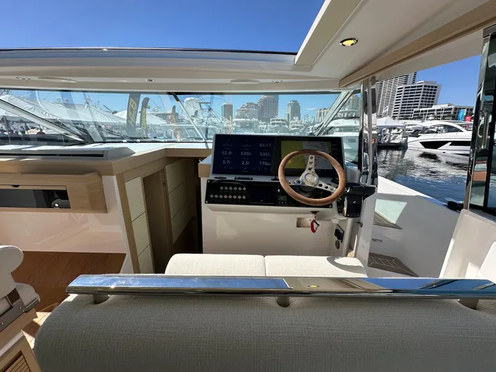  Yacht Photos Pics Interior view of 2026 Delta Powerboats 48 Coupe, featuring modern helm and cityscape background.