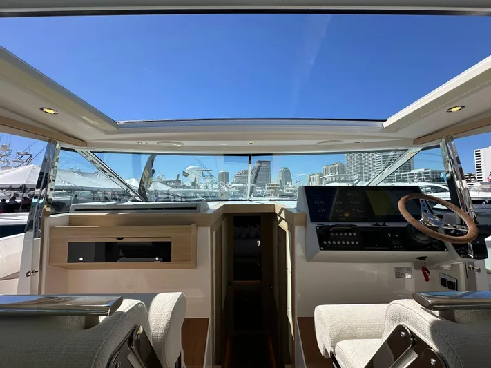  Yacht Photos Pics Interior view of 2026 Delta Powerboats 48 Coupe, showcasing modern helm and city skyline.