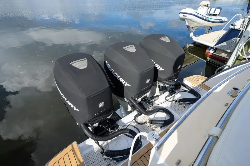 Scout Yacht Photos Pics Triple Mercury outboard engines on a 2019 MJM 43z boat, docked by the water.