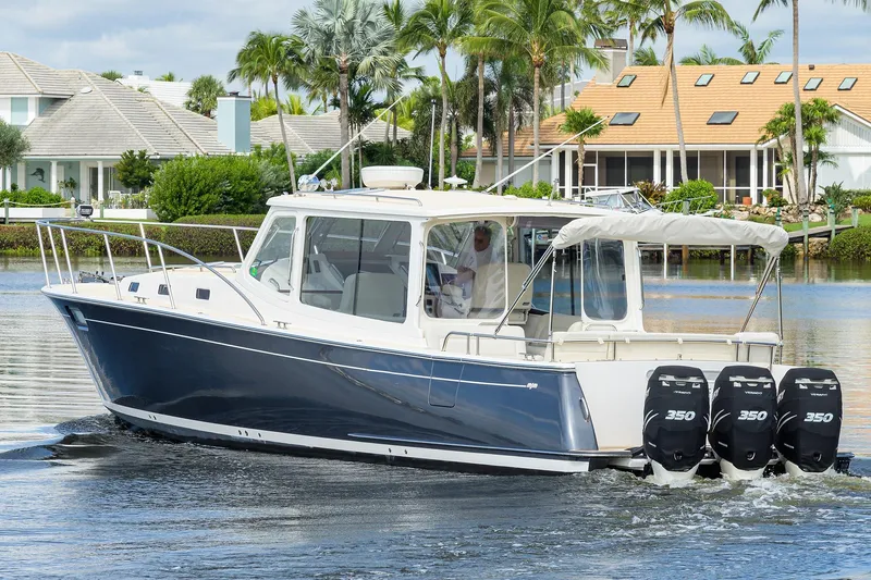 Scout Yacht Photos Pics 2019 MJM 43z boat cruising on a scenic waterfront with palm trees and houses.