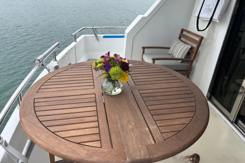  Yacht Photos Pics Wooden table with flowers on a 1986 Maiora Phantom yacht deck.