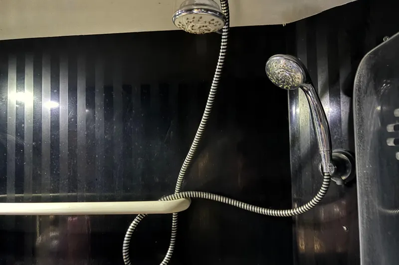  Yacht Photos Pics Shower area in 1986 Maiora Phantom yacht with dual showerheads and sleek black paneling.