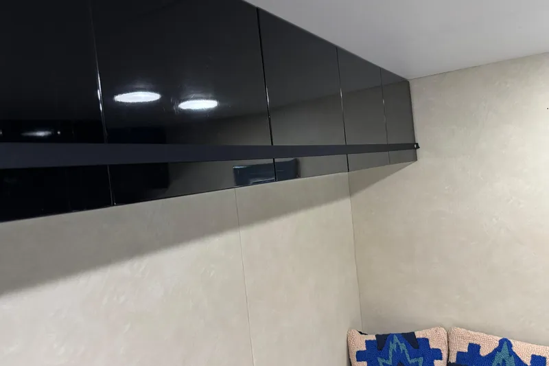  Yacht Photos Pics Sleek black cabinets in a 1986 Maiora Phantom interior, with modern lighting and textured cushions.