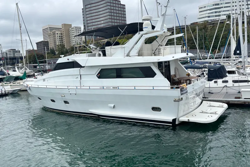  Yacht Photos Pics Luxury 1986 Maiora Phantom yacht docked in a marina, surrounded by cityscape and other boats.
