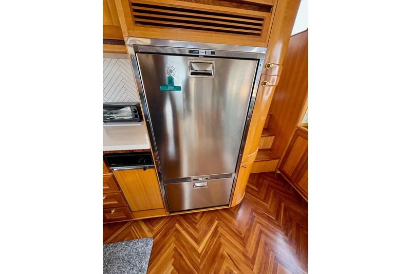 Eagles Soar Yacht Photos Pics Stainless steel refrigerator in a wooden kitchen on a 2000 Hampton 490 yacht.