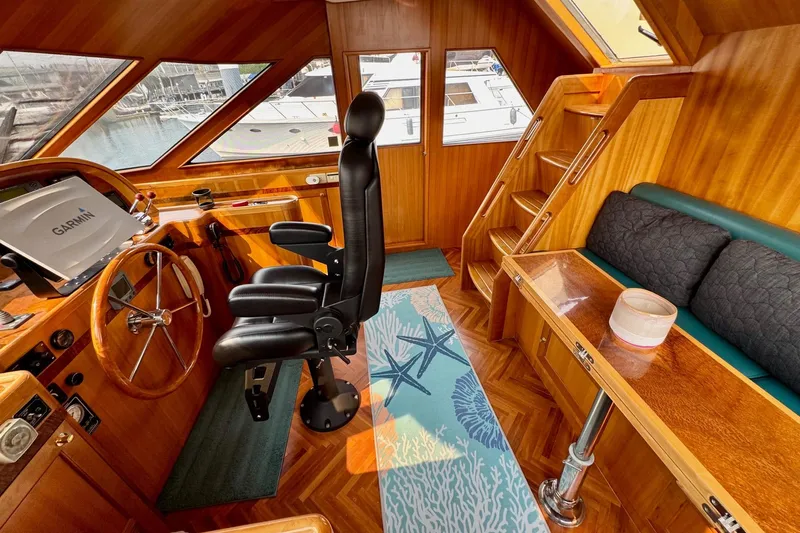 Eagles Soar Yacht Photos Pics Luxurious 2000 Hampton 490 yacht interior with wooden helm, black captain's chair, and nautical decor.