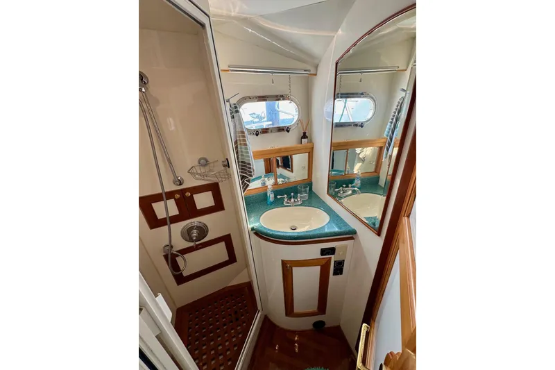 Eagles Soar Yacht Photos Pics Luxurious bathroom in 2000 Hampton 490 yacht with shower, sink, and mirror.