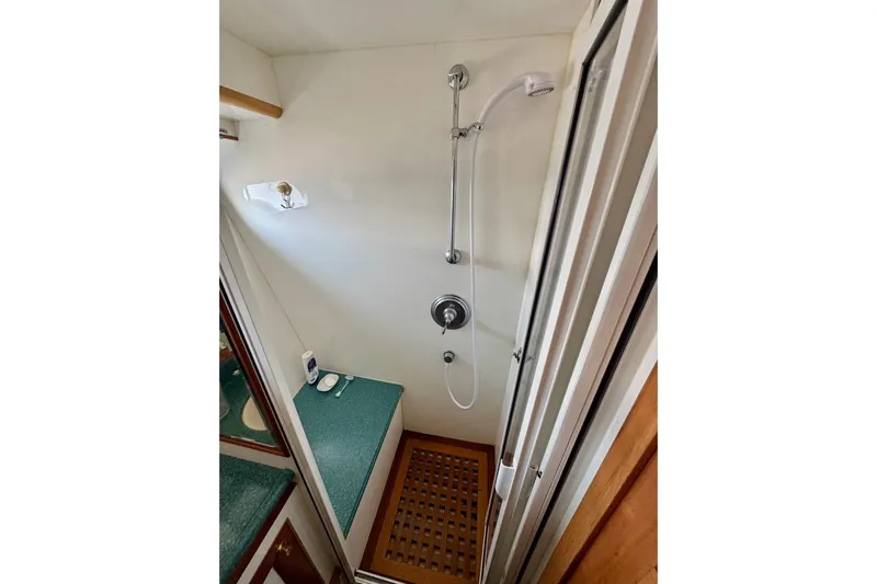 Eagles Soar Yacht Photos Pics Compact shower area in a 2000 Hampton 490 yacht, featuring modern fixtures and teal countertop.