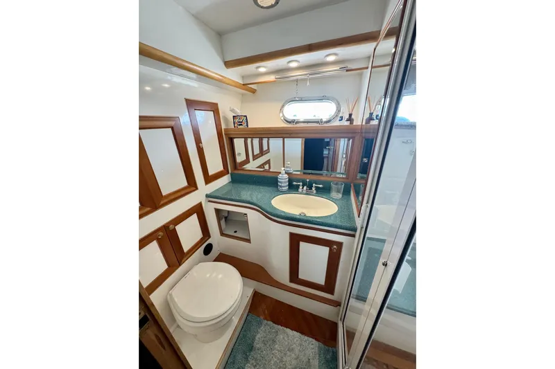 Eagles Soar Yacht Photos Pics Luxurious bathroom in 2000 Hampton 490 yacht with wood accents and modern fixtures.