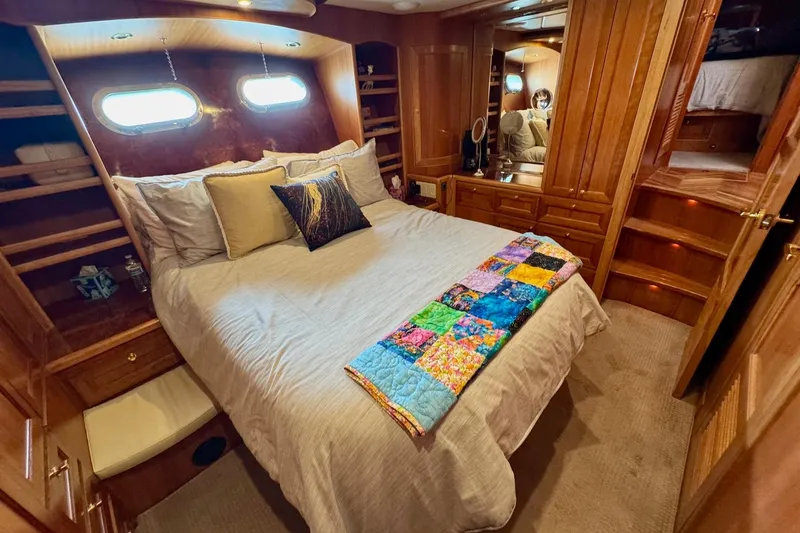 Eagles Soar Yacht Photos Pics Luxurious bedroom in 2000 Hampton 490 yacht with wood paneling and colorful quilt.